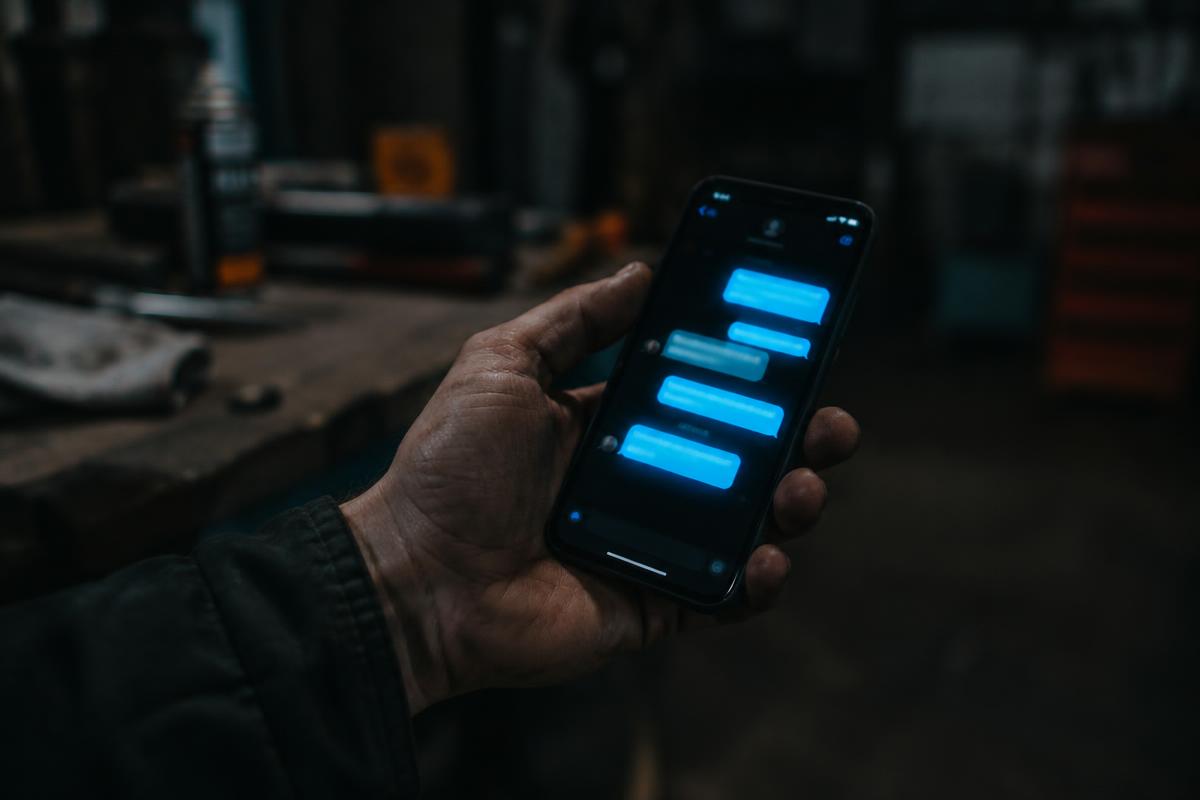 Phone showing a glowing text thread in a workshop